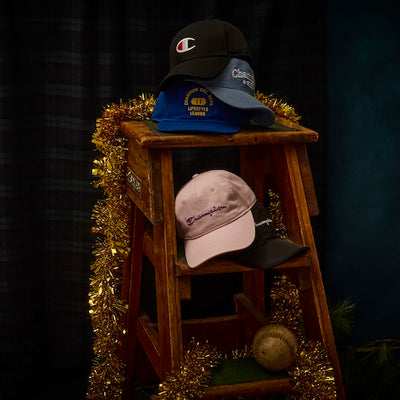 Collection of Champion hats on a wooden ladder with tinsel against a dark background