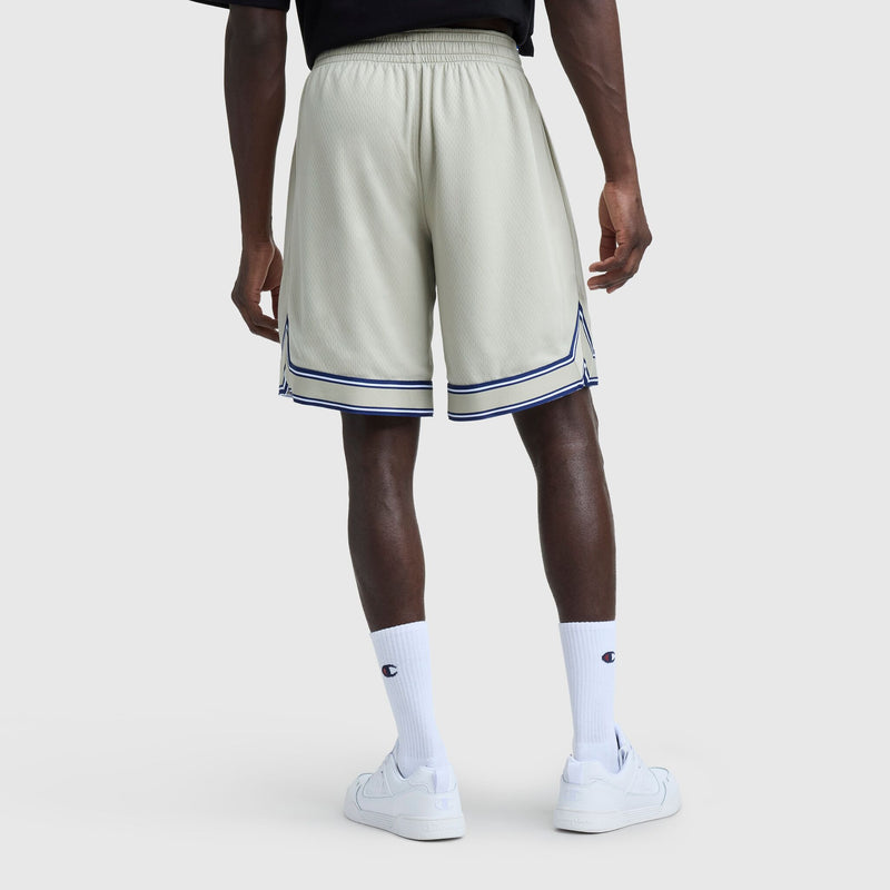 A person is shown from behind wearing Champion 10" Gridiron Reversible Shorts with the Script Logo in light gray mesh and dark blue trim, paired with white crew socks featuring the Champion logo and white sneakers, against a plain background.