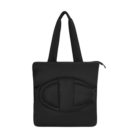 The Champion Quilted Billie Tote is a black, quilted bag with two thick handles, a bold raised “C” on the front, and a zipper closure. Its minimalist design makes it perfect for everyday use.