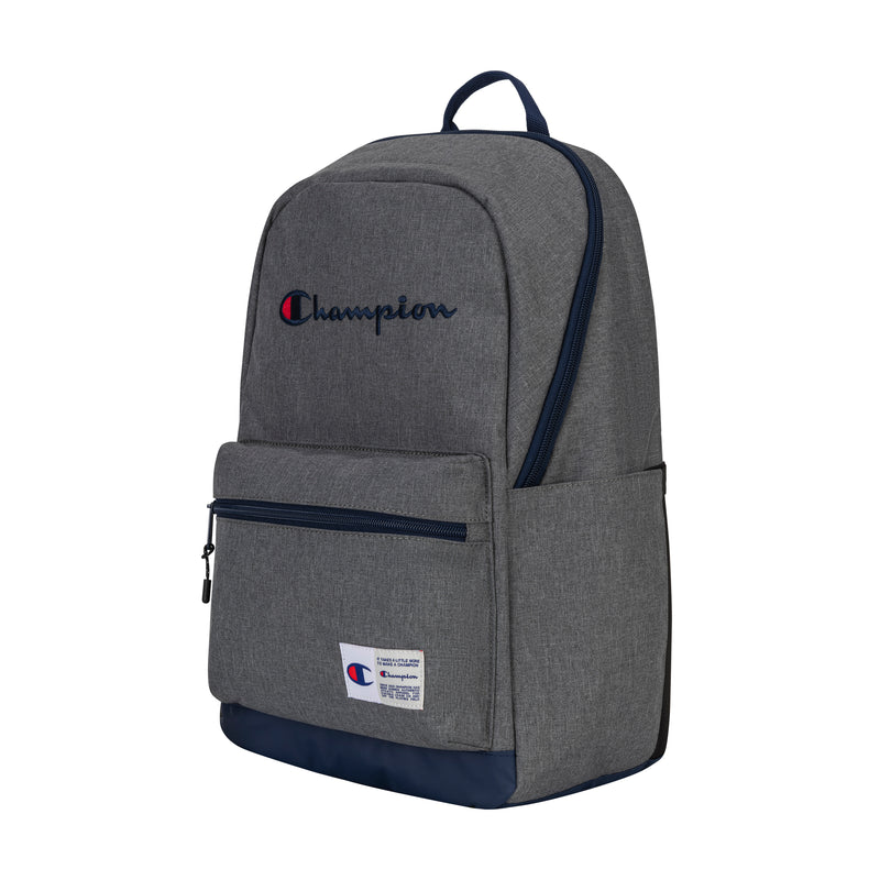 The Champion System Backpack is gray with a navy blue bottom, multiple compartments, a front zip pocket, side pocket, padded laptop sleeve, top handle, and features the embroidered "Champion" logo and a branded patch near the bottom.