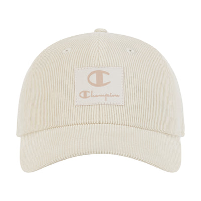 The Champion Ridge Corduroy Adjustable Cap features a beige corduroy design, a front square patch with the Champion logo and tan "Champion" lettering, an adjustable back closure, and vintage-inspired style.