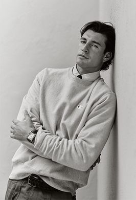 Man wearing a light-colored sweater against a plain background